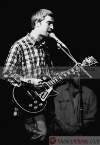 Noel Gallagher performing with his Les Paul Custom with sticker